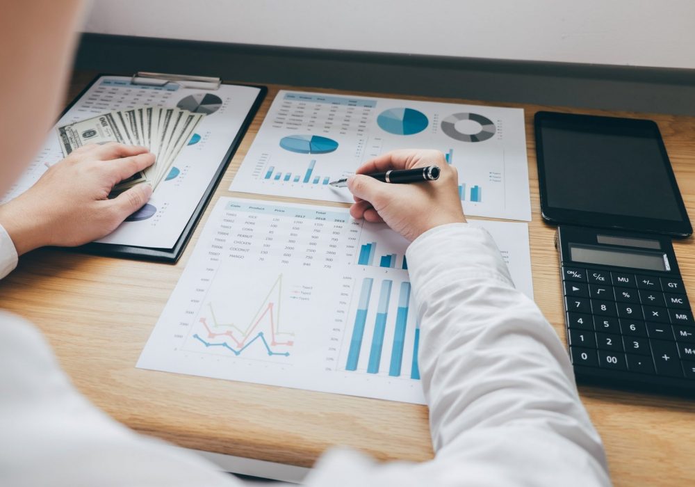 Businessman working on a graph document financial report and analysis calculation investment cost